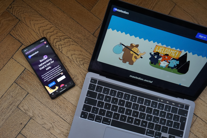 A picture of a computer and a phone looking at mastodon.social, a popular Mastodon instance on the Fediverse.